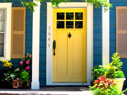 Жълта входна врата на къща със синя фасада