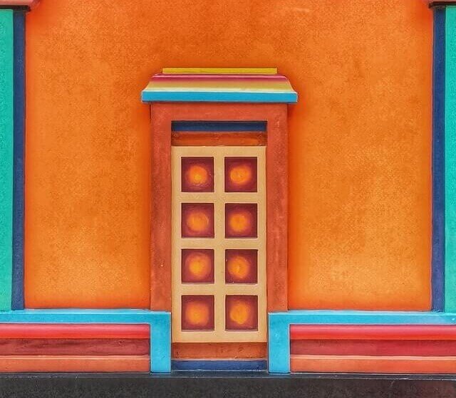 Сграда с боядисана фасада в няколко цвята и врата