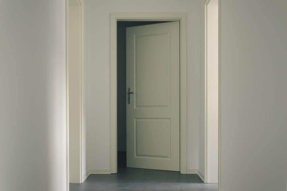 Отворена бяла врата с бели первзи